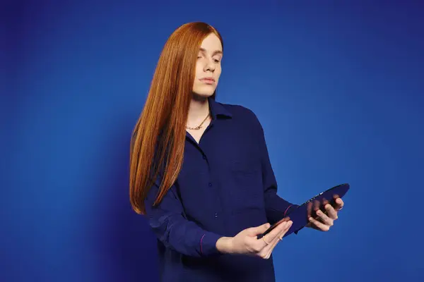 A fashionable queer man flaunts his stylish outfit and long red hair, radiating confidence. — Stock Photo