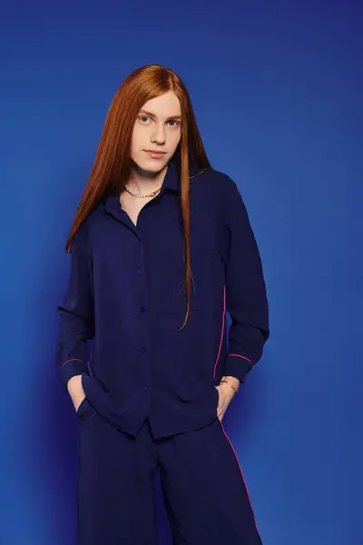 Fashionable young individual showcases modern style and confidence with striking red hair. — Stock Photo