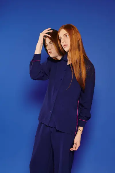 A fashionable young man with striking long red hair stands confidently, styled in modern attire. — Stock Photo