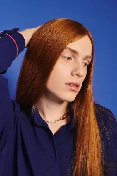 A fashionable young man with long red hair poses elegantly, exuding confidence and style. — Stock Photo