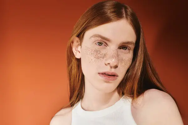 Un joven guapo con el pelo largo y rojo y pecas únicas muestra su aspecto de moda. - foto de stock