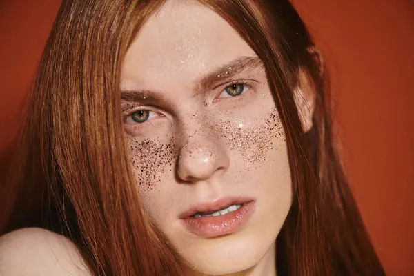 A trendy young queer man showcases his long red hair and dazzling freckles with confidence. — Stock Photo