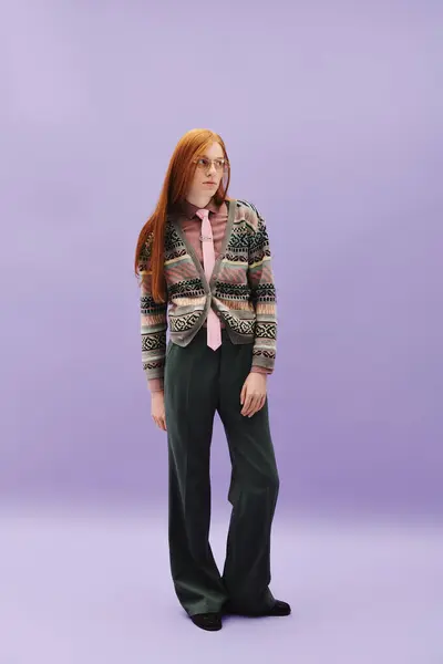 A young man with long red hair poses in a stylish outfit against a soft pastel backdrop. — Stock Photo