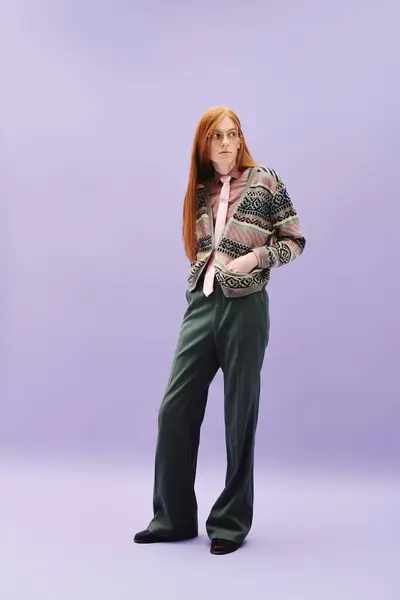Queer young man with long red hair showcases trendy outfit against a colorful backdrop. — Stock Photo