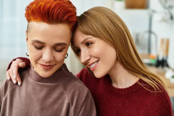 Dos mujeres jóvenes se abrazan cariñosamente en casa, disfrutando de la compañía de los demás con comodidad. — Stock Photo