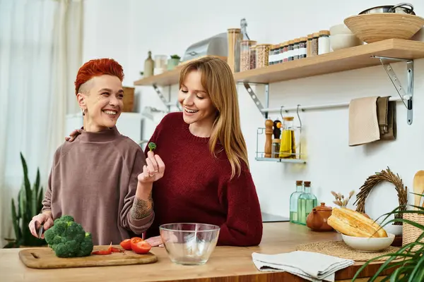 Two young women share joy and laughter while preparing a healthy meal at home. — Stock Photo