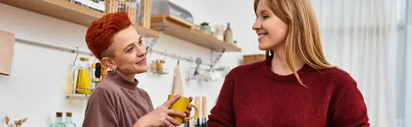 A beautiful young couple shares smiles and laughter while relaxing in their cozy modern apartment, banner — Stock Photo