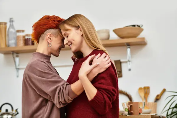Due giovani donne condividono un tenero abbraccio nel loro elegante appartamento, irradiando amore e felicità. — Foto stock