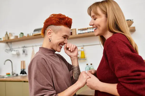 Two beautiful women share a joyful moment in their contemporary apartment, celebrating love. — Stock Photo