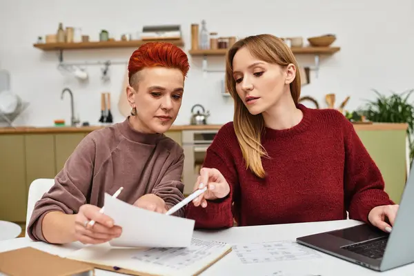 Due belle giovani donne collaborano a casa, circondate da arredi moderni e creatività.. — Foto stock