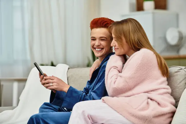 Two beautiful young women enjoy each other company in their cozy apartment, laughing and relaxing. — стоковое фото