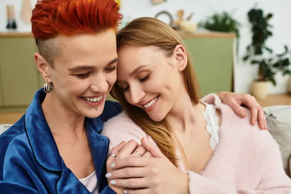Two beautiful women embrace joyfully at home, enjoying each other's presence and love. — Stock Photo