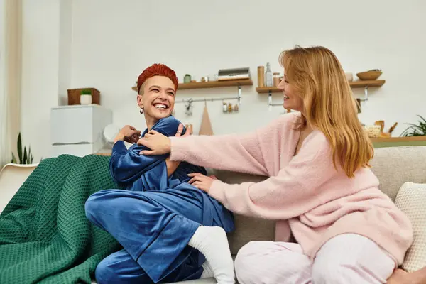 Two young women share laughter and joy while relaxing in their stylish apartment space. — Stock Photo