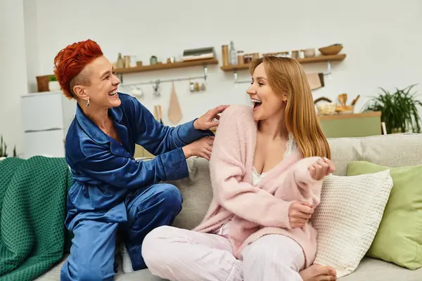 A joyful lesbian couple shares laughter and playfulness in their cozy space. — Stock Photo