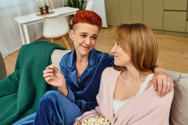 Couple enjoys each other's company with popcorn while lounging in their stylish living room. — Stock Photo
