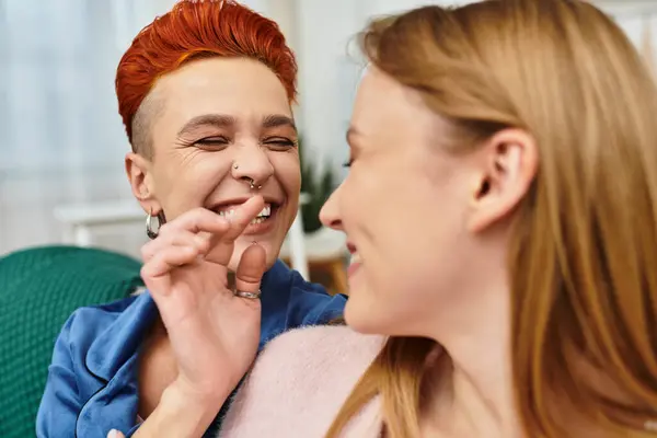 Two young women share laughter and affection in their contemporary apartment filled with warmth. — Stock Photo