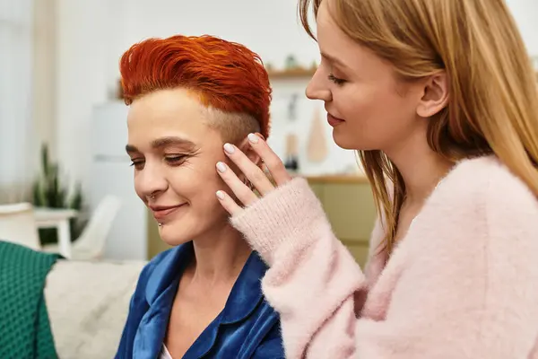 Two young women share a tender moment at home, enjoying each others company in a stylish setting. — Stock Photo