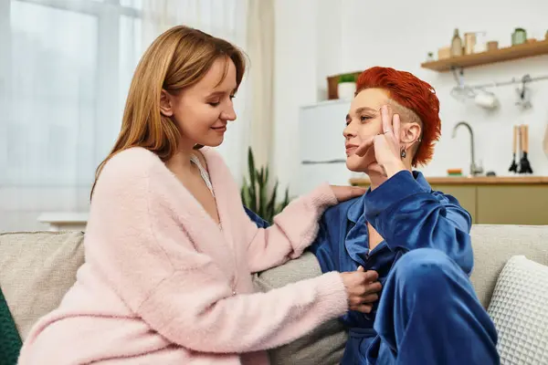 Two young women share a warm moment in their stylish apartment, radiating love and joy. — Stock Photo