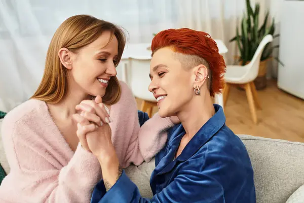 Two young women smile at each other, enjoying a cozy moment together at home. — Fotografia de Stock