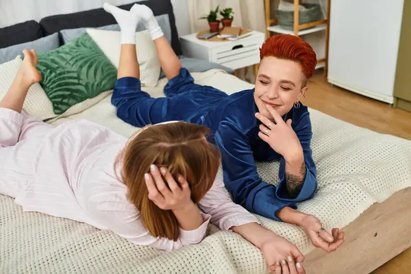 Deux belles jeunes femmes se détendent dans leur chambre, profitant de leur compagnie et riant. — Photo de stock