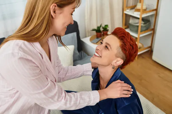 Two beautiful young women share a tender moment in their modern bedroom, surrounded by love. — Stock Photo