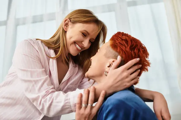In a stylish apartment, a beautiful lesbian couple embraces each other, radiating joy and love. — Stock Photo