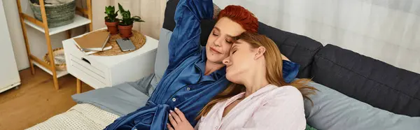 Two beautiful young women embrace in a stylish bedroom filled with warmth and love, banner — Stock Photo