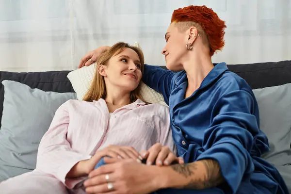Deux belles jeunes femmes partagent un moment tendre dans leur chambre confortable, soulignant leur amour. — Photo de stock