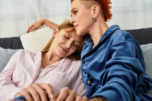 Two beautiful young women embrace deeply in their stylish bedroom, radiating love and warmth. — Stock Photo