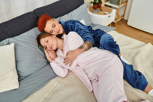 Two beautiful young women embrace tenderly in their cozy bedroom, radiating love and comfort. — Stock Photo