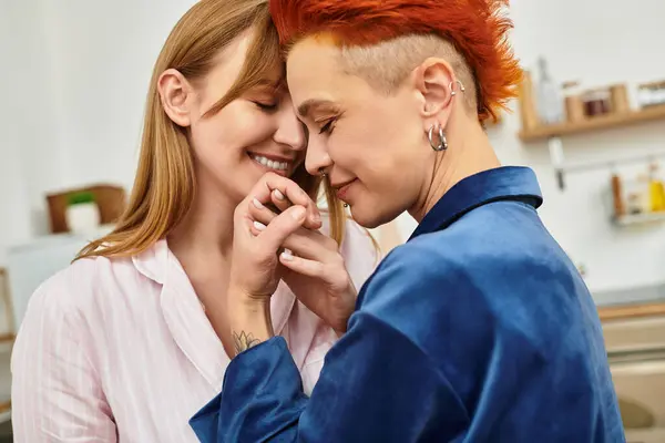 El amor auténtico brilla mientras dos mujeres se conectan íntimamente en su hogar moderno. - foto de stock