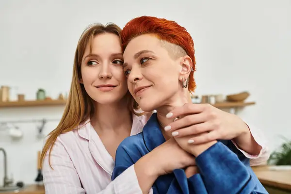 In a cozy bedroom, two beautiful young women embrace each other tenderly, showcasing their love. — Stock Photo