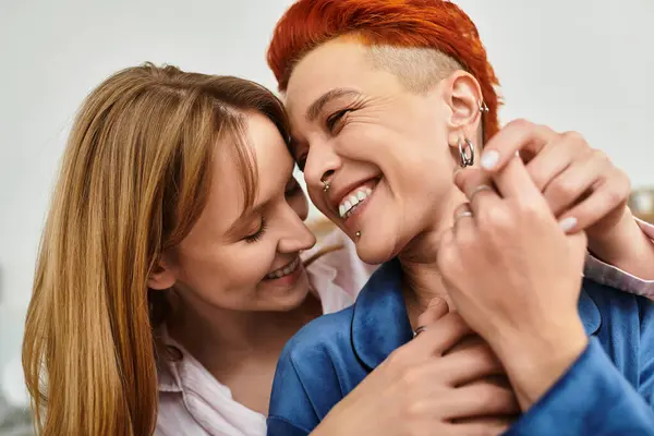 Dos mujeres jóvenes comparten un momento tierno en su elegante habitación, irradiando amor y felicidad. - foto de stock