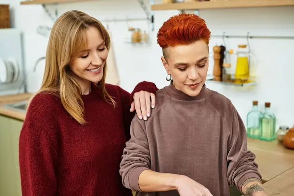 In einer stilvollen Wohnung genießt ein fröhliches lesbisches Paar einen zarten Moment beim gemeinsamen Kochen. — Stockfoto