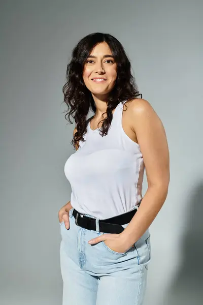 Además de la mujer de tamaño emana confianza en una camiseta blanca elegante y vaquero casual. - foto de stock