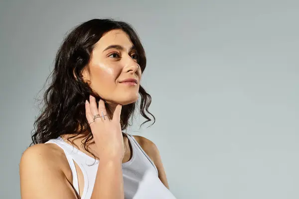 Confidence shines through a beautiful young plus size woman on neutral backdrop. — Stock Photo