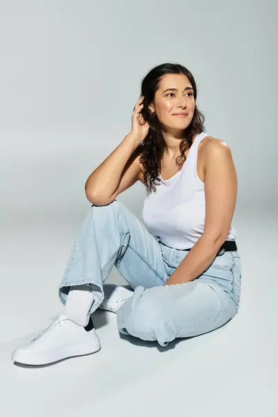 Plus size woman relaxing in a beautiful studio setting with a cheerful smile. — Stock Photo