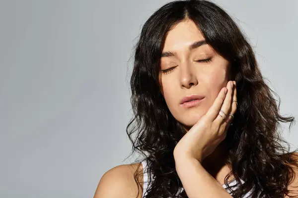 Brunette woman expresses serenity in a stylish studio setting. — Stock Photo