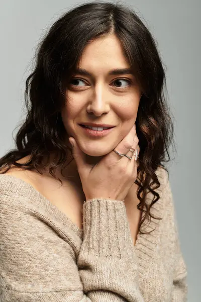 Brunette woman with curly hair smiles gently in a cozy studio setting. — Stock Photo