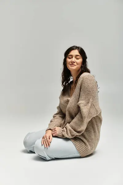 Embracing confidence and beauty in a serene studio setting with cozy fashion. — Stock Photo