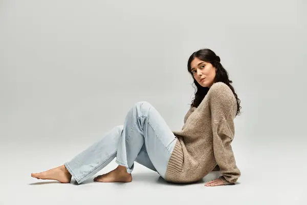 Embracing beauty with youthful confidence in a warm beige sweater and relaxed pose. — Stock Photo