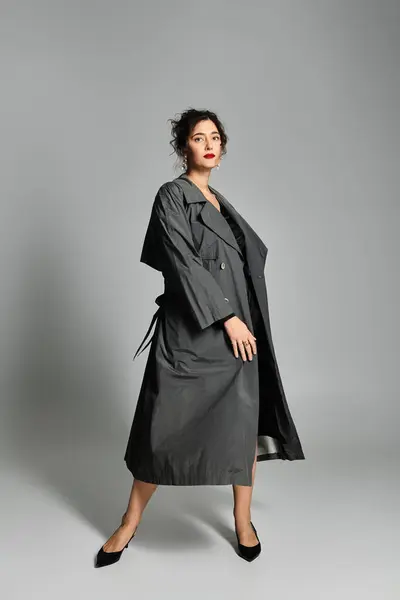 Giovane donna in elegante abbigliamento posa con grazia in moderno ambiente monolocale. — Foto stock