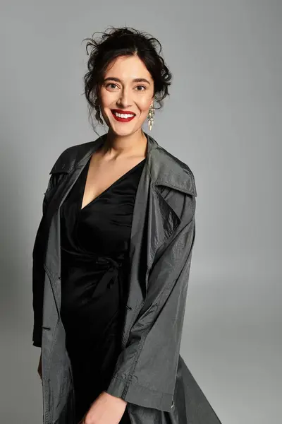 Elegante giovane donna in elegante abbigliamento nero posa con grazia in ambiente studio. — Foto stock