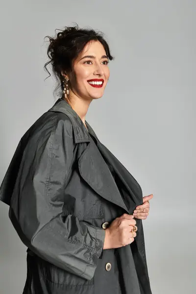Elegante donna bruna in abbigliamento elegante mette in mostra la bellezza in un ambiente di studio. — Foto stock