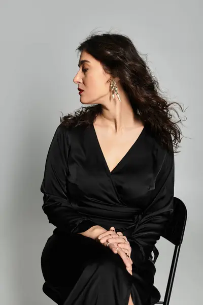 Captivating plus size beauty in elegant black attire poses gracefully in studio. — Stock Photo