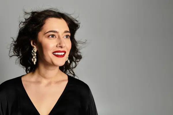 Elegant brunette woman in stunning attire poses gracefully in a studio setting. — Stock Photo