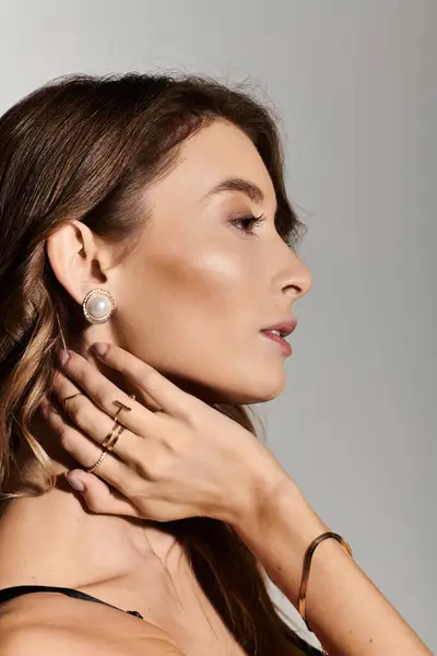 Elegante joven que exhibe un estilo de lencería moderno y accesorios elegantes en iluminación suave. - foto de stock
