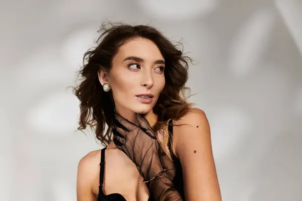 Elegant young woman exuding confidence in stylish lingerie attire with graceful allure. — Stock Photo