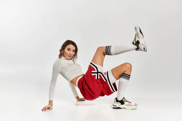 Young woman showcasing chic and trendy attire in a minimalist studio setting. — Stock Photo