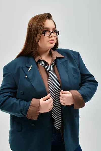 A confident young plus size woman poses in a stylish oversized blazer and tie. — Stock Photo